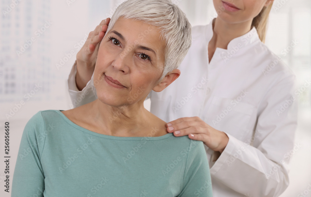 Mature Woman having chiropractic back adjustment. Osteopathy, Physiotherapy, Sport injury rehabilitation concept, holistic care Mature Woman having chiropractic back adjustment. Osteopathy, Physiotherapy, Sport injury rehabilitation concept, holistic care