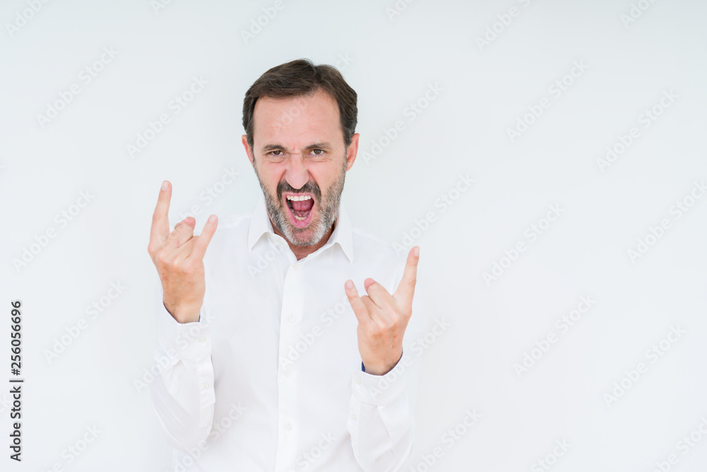Elegant senior man over isolated background shouting with crazy expression doing rock symbol with hands up. Music star. Heavy concept. Elegant senior man over isolated background shouting with crazy expression doing rock symbol with hands up. Music star. Heavy concept.