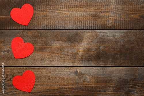 Red hearts on brown wooden background photo