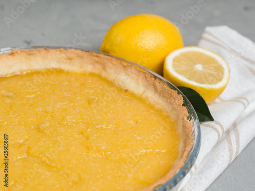 lemon tart with slice of lemons closeup on stone background, copy space.