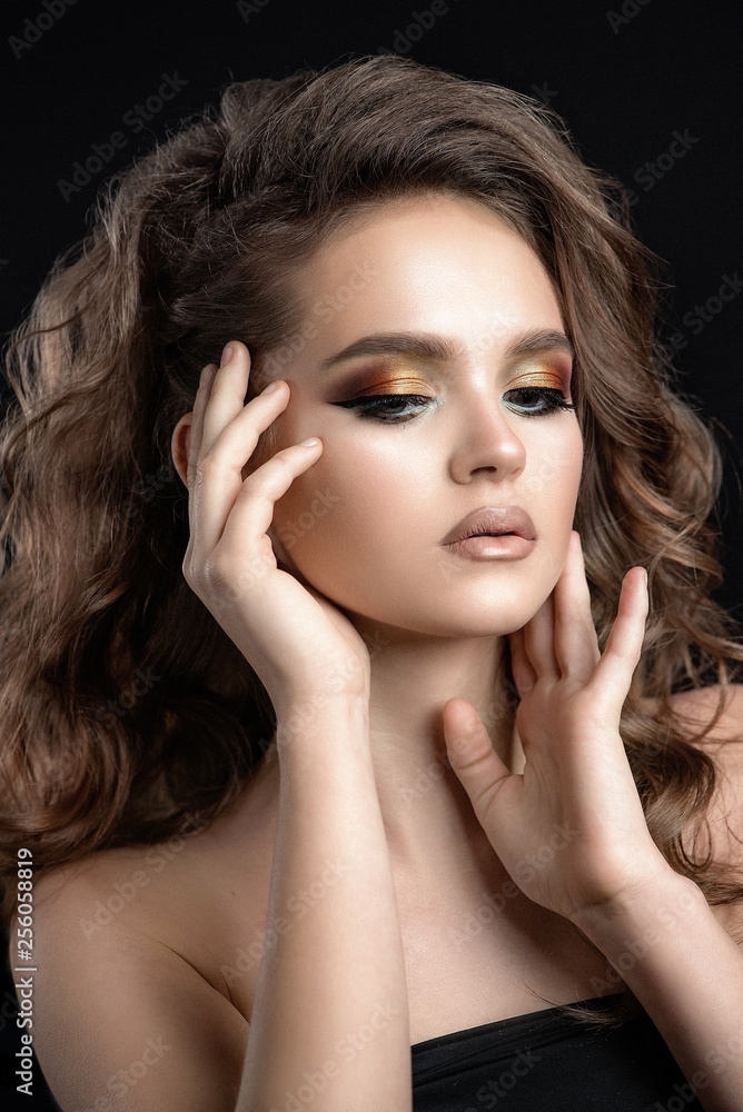 A girl with beautiful golden eye makeup and curly hair A girl with beautiful golden eye makeup and curly hair