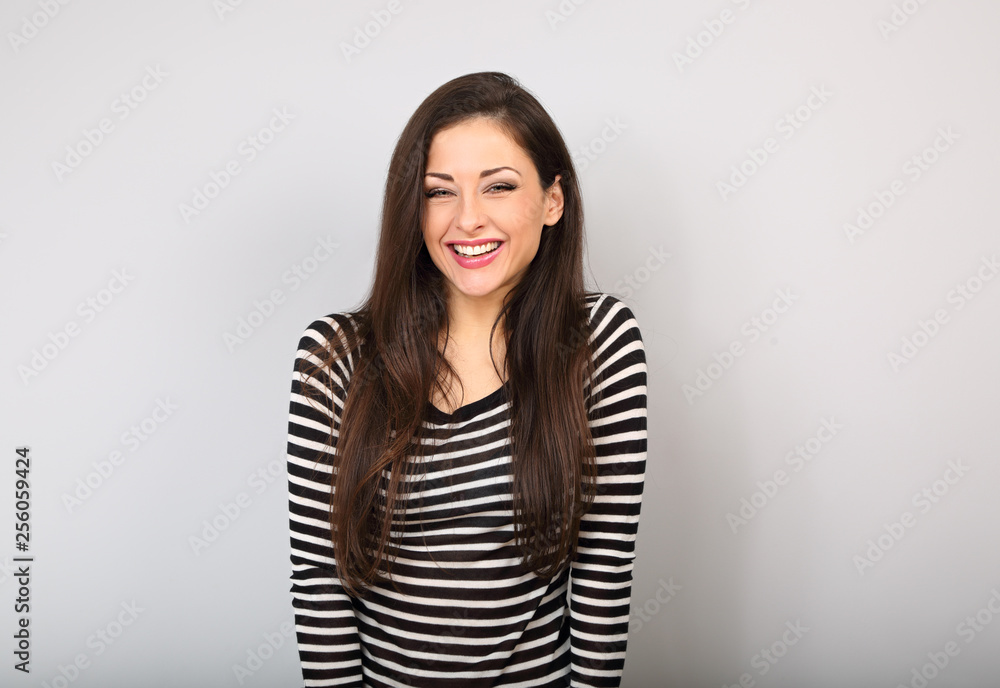 Beautiful young laughing casual woman with wide toothy smile on blue background. Beautiful young laughing casual woman with wide toothy smile on blue background.