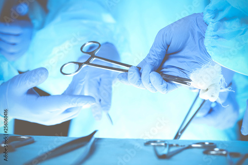 Surgeons hands holding surgical scissors and passing surgical equipment, close-up. Health care and veterinary concept