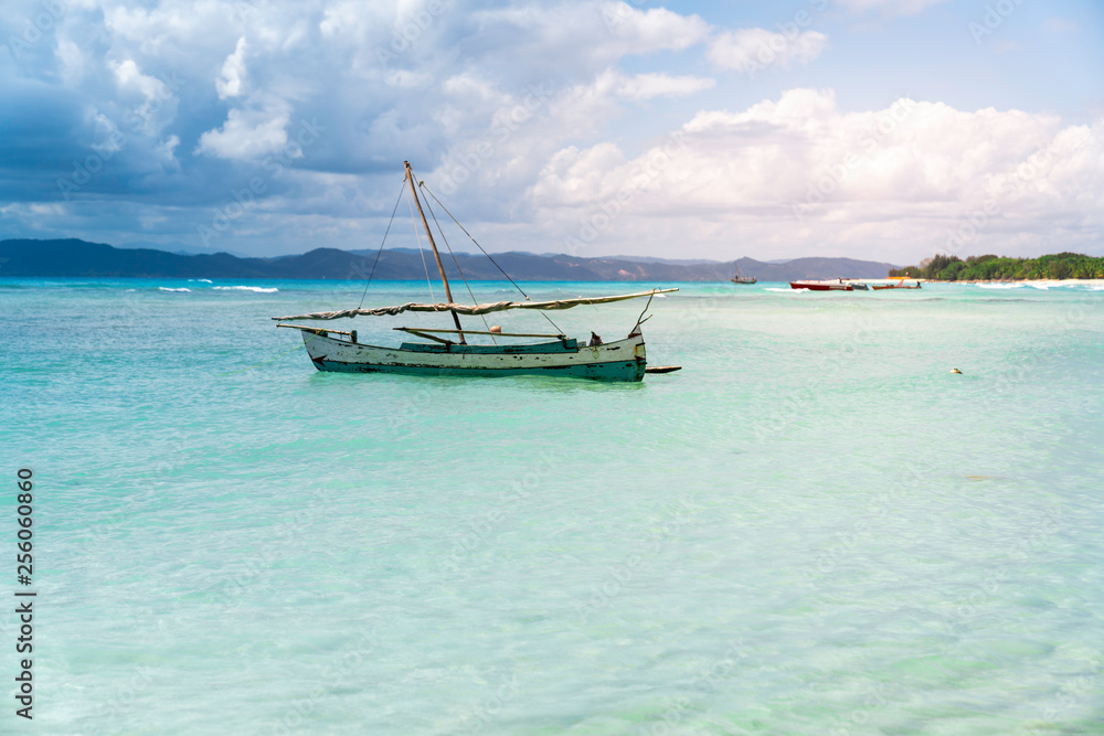 Fototapeta premium beautiful tropical beach in madagascar and a wooden boat in the ocean. nosy iranja exotic beach with crystal clear water
