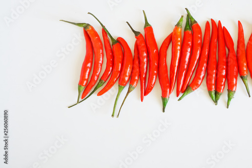 Pods of red chili peppers lie on a white clean surface. Seasoning and healthy food. Free space for inscriptions