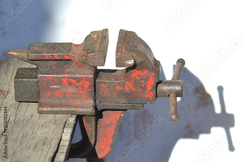 Old red vise on a wooden table. photo