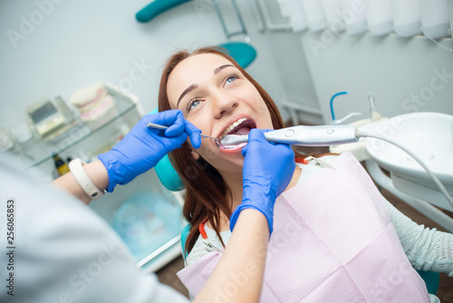 Beautiful  cheerful girl in the dentist s chair. Dental treatment. Dental clinic. Teeth whitening procedure
