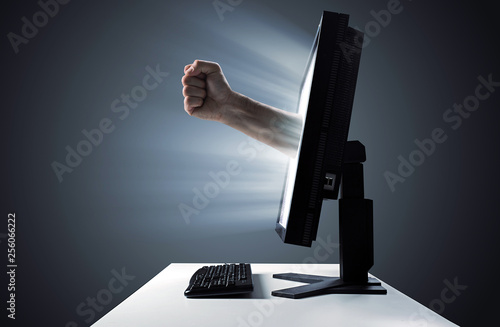 Vászonkép Male fist emerging out of the display - violent in the Internet symbol