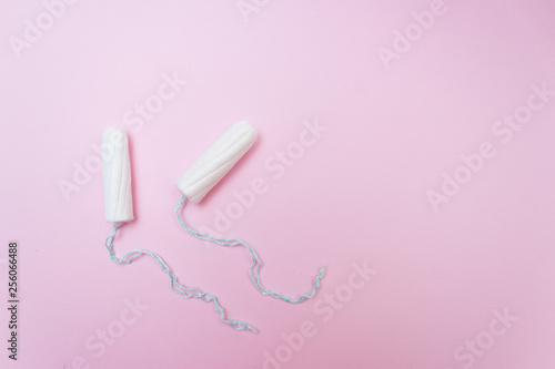Menstrual period concept. Woman hygiene protection. Cotton tampons on pink background. Top view, flat lay. © Maryna