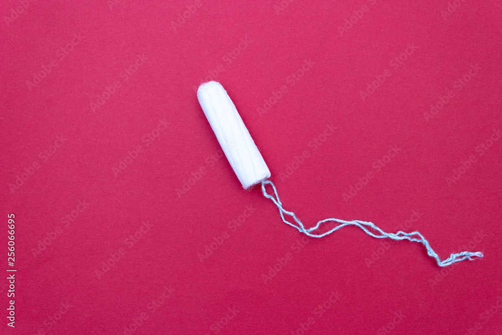 Tampon for menstruation. The concept of critical days. It's red Tampon for menstruation. The concept of critical days. It's red