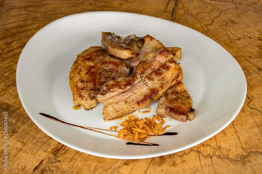 Roasted pork ribs, garnished with onion chips. Roasted pork ribs, garnished with onion chips.