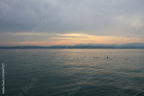 The sun breaking through the clouds over lake Garda Italy