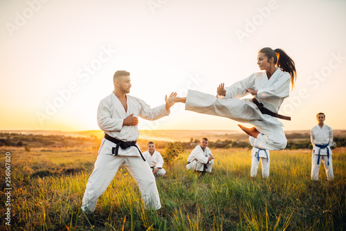 Female karate fighter trains kick in flight photo