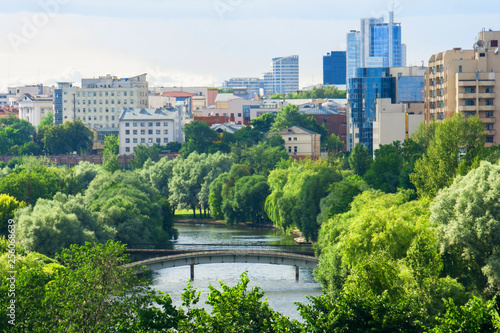 Beautiful view from the height of the spring city center with diverse architecture and a park along the city river.