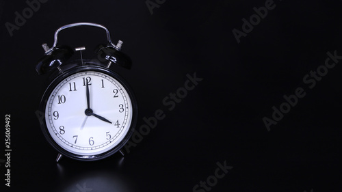 Close up image of old black vintage alarm clock. Four o'clock