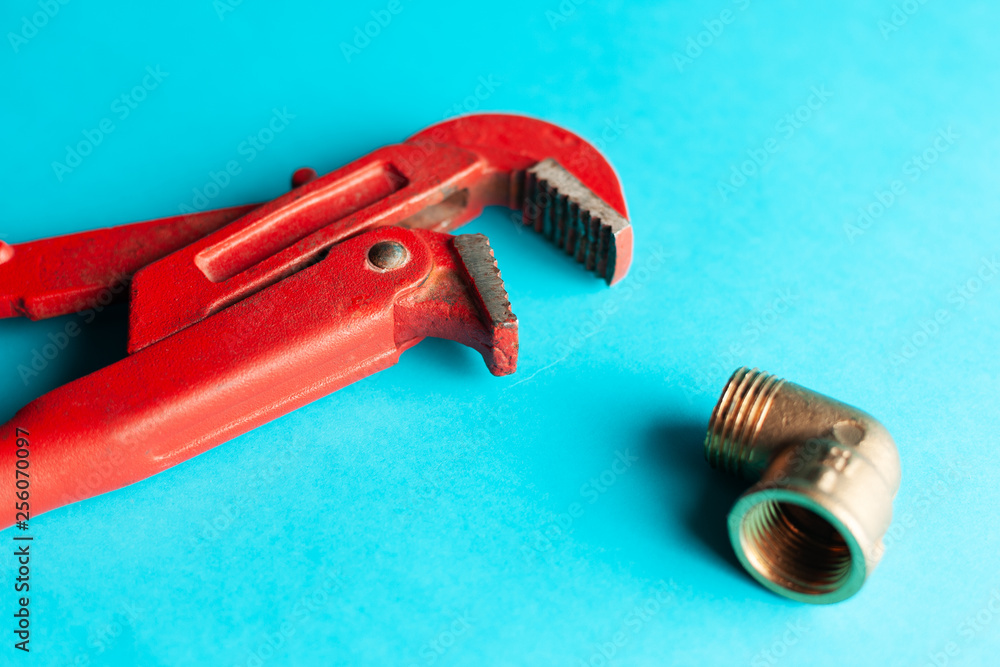 A monkey wrench on the blue background with some fitting connectors. for design and decoration A monkey wrench on the blue background with some fitting connectors. for design and decoration