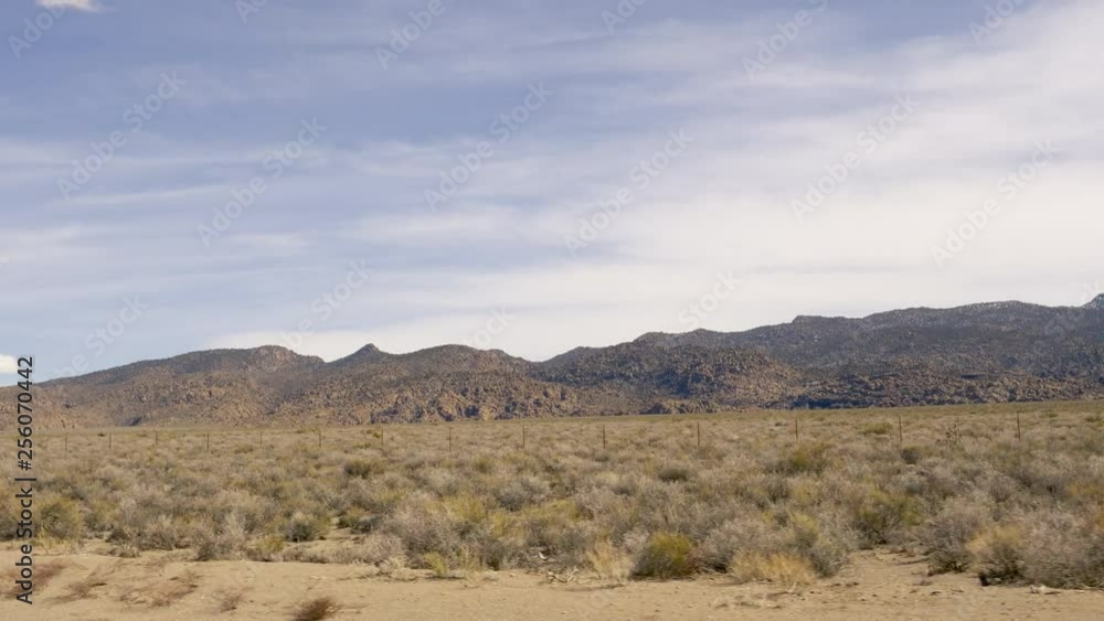 Passing sagebrush flat with barren hills in distance in the Nevada