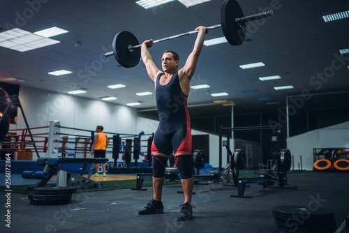 Strong powerlifter doing deadlift a barbell in gym