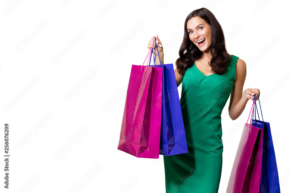 Happy young woman wearing green dress standing isolated over white background, carrying shopping bags. Satisfied girl after successful shopping in the mall. copy space. sale. - Image      