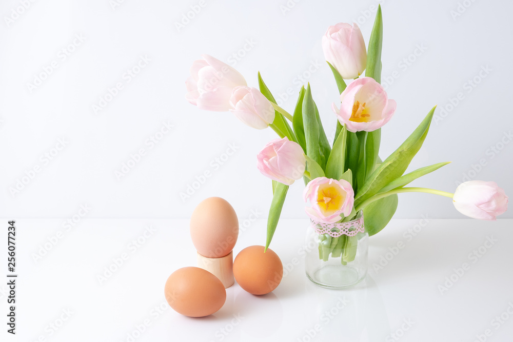custom made wallpaper toronto digitalthree colored eggs lie next to a bouquet of pink tulips in a glass jar. The concept of Easter