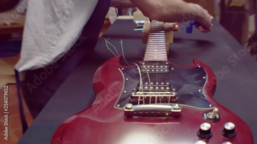 Guitar Maker changes electric guitar strings