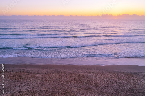 Sunrise over empty ocean beach with copy space