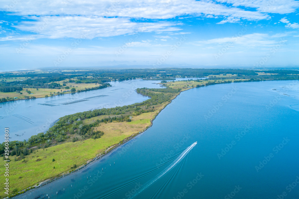 Boat sailing on the Manning River leaving water trail - aerial view