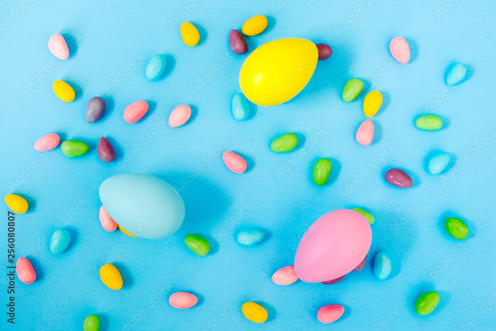 Easter decoration eggs and candy on blue background. Easter background