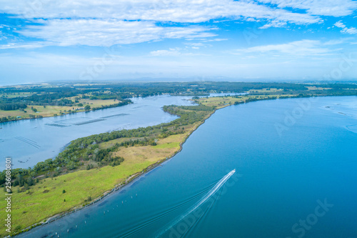 Boat sailing on the Manning River leaving water trail - aerial view