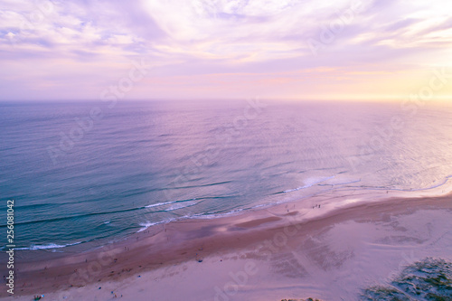 Aerial view of people enjoying the ocean beach at sunset in Australia photo