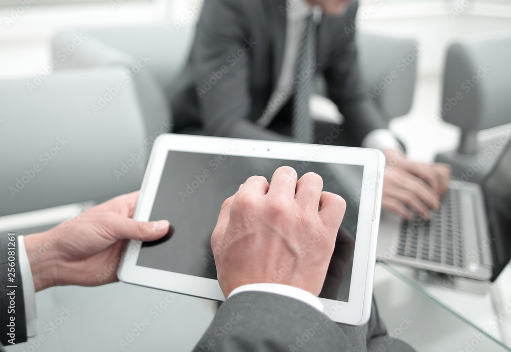 close up.businessman with a digital tablet in a modern office close up.businessman with a digital tablet in a modern office