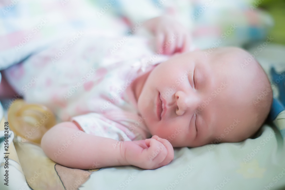 small child is smiling in his sleep. newborn girl sleeps sweetly in a crib. small child is smiling in his sleep. newborn girl sleeps sweetly in a crib.