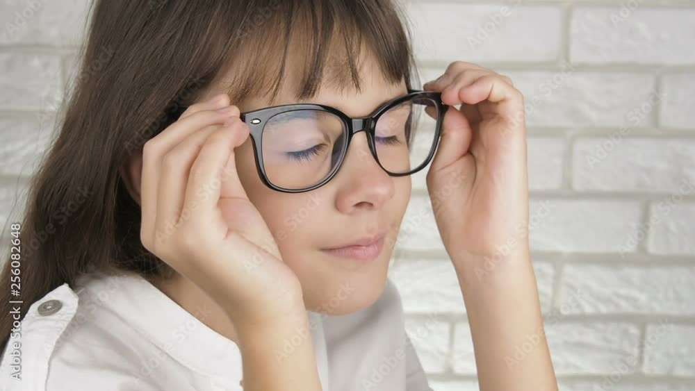Portrait of a child with glasses. A little girl with poor eyesight puts on glasses. Portrait of a child with glasses. A little girl with poor eyesight puts on glasses.