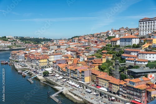 A view of Porto and the River Duoro. Photo taken from the Dom Luis bridge. Many buildings are visible with terracotta tiled roofs.