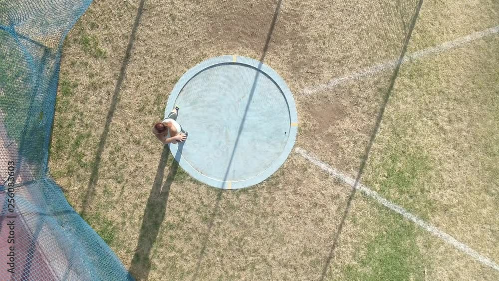 Aerial footage of a female discus athlete doing practice throws in a