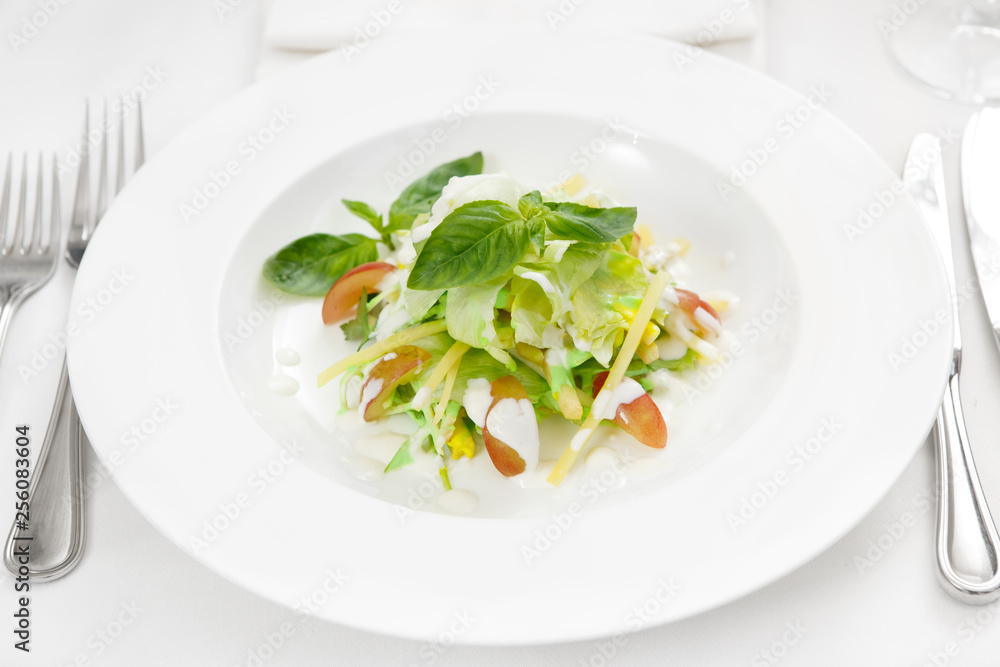 Plate of health. Closeup of a salad combining cheese, grapes, lettuce and greenies with sauce Plate of health. Closeup of a salad combining cheese, grapes, lettuce and greenies with sauce
