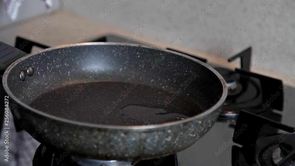 On the included stove, the pan is heated for cooking and olive oil is poured on it On the included stove, the pan is heated for cooking and olive oil is poured on it