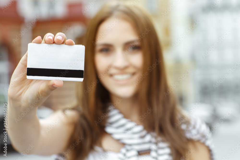 The thing you need for shopping. Selective focus shot of a young smiling brunette shopper showing credit card - obrazy, fototapety, plakaty 