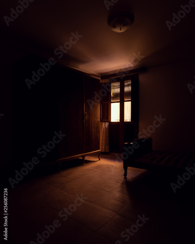 Interior of a room with a window in the background through which light enters forming a beautiful backlight and revealing the furniture inside