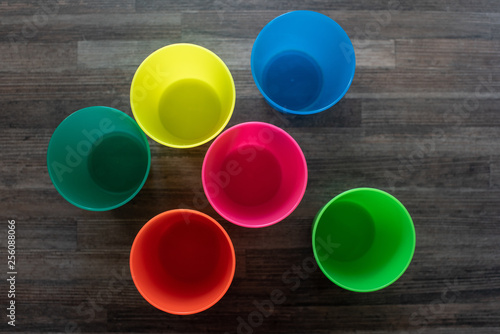 Colorful plastic cups shot directly above on wooden surface