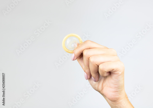 Woman's hands holding male condom.