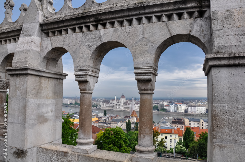 View of pillars from the public park, Fisherman's Bastion, in Budapest. In the background is the Hungarian Parliament building.