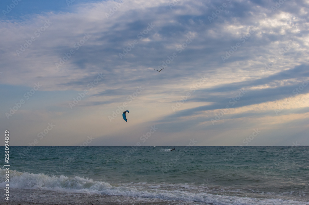 kitesurfer rides a kite-surf on waves of the sea kitesurfer rides a kite-surf on waves of the sea