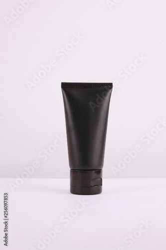 Black and white cosmetic containers on white background