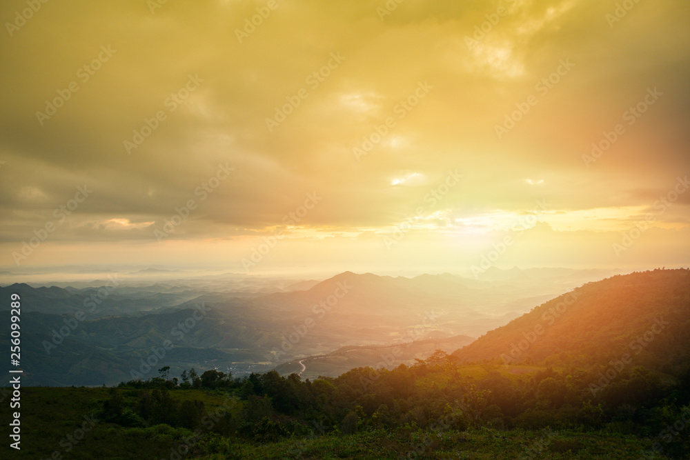 Sunrise or sunset over colorful view on hill mountain nature landscape yellow sky dramatic cloud background