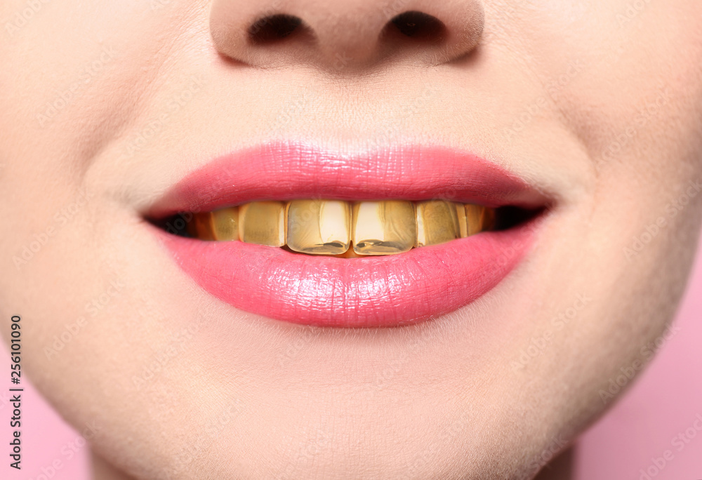 Naklejka premium Beautiful young woman with gold teeth, closeup