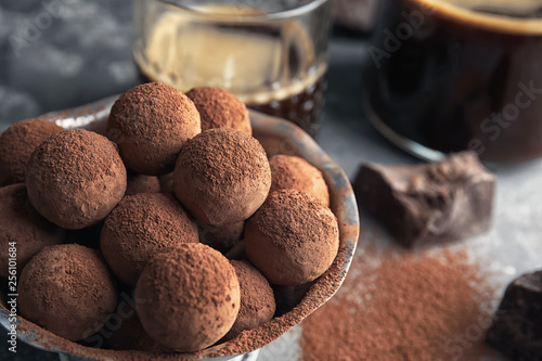Bowl of tasty chocolate truffles on table, closeup with space for text