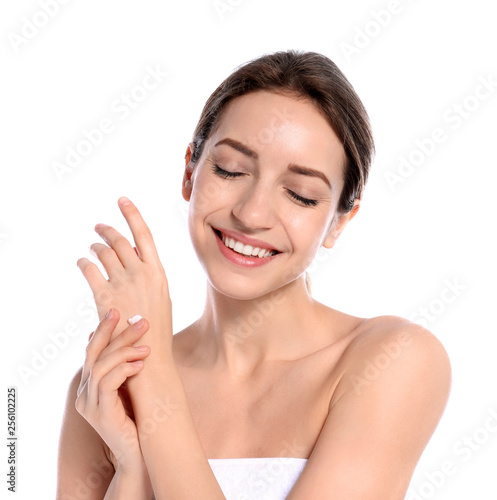 Young woman applying cream on her hand against white background. Beauty and body care
