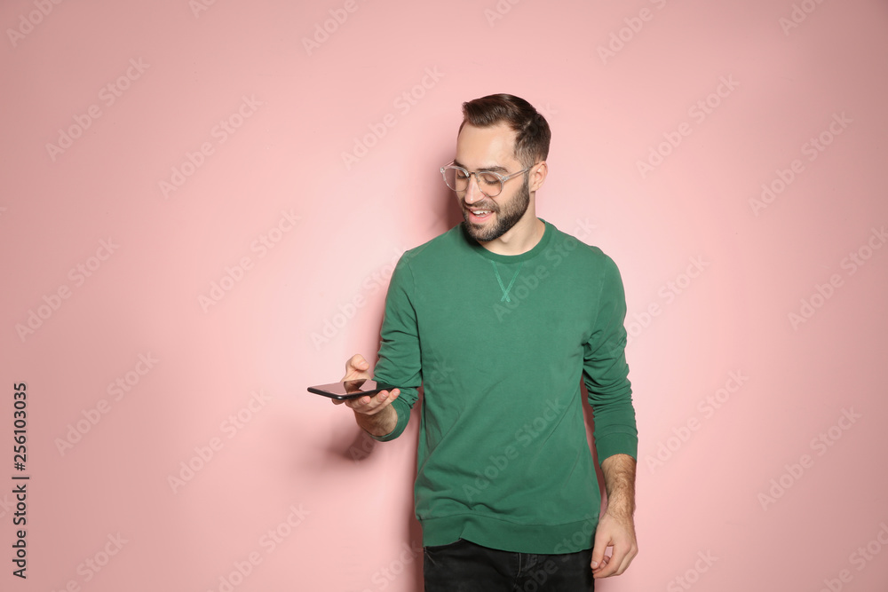 Handsome young man with mobile phone on color background Handsome young man with mobile phone on color background