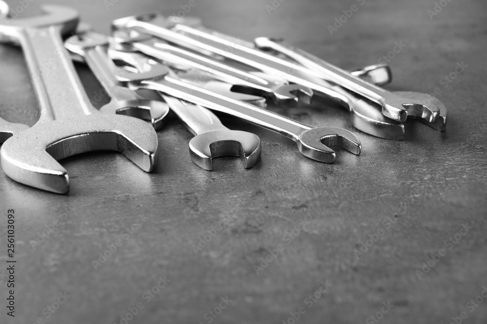 New wrenches on grey background, closeup with space for text. Plumber tools New wrenches on grey background, closeup with space for text. Plumber tools